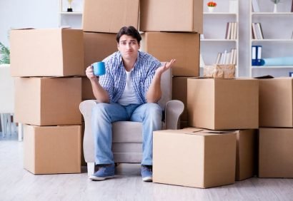 Young man moving in to new house with boxes Young man moving in to new house with boxes